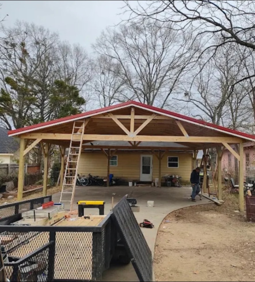 Custom wood carport with red metal roof built by Power Drywall in Cedartown, GA